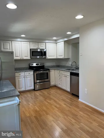 a kitchen with stainless steel appliances granite countertop a stove sink and cabinets