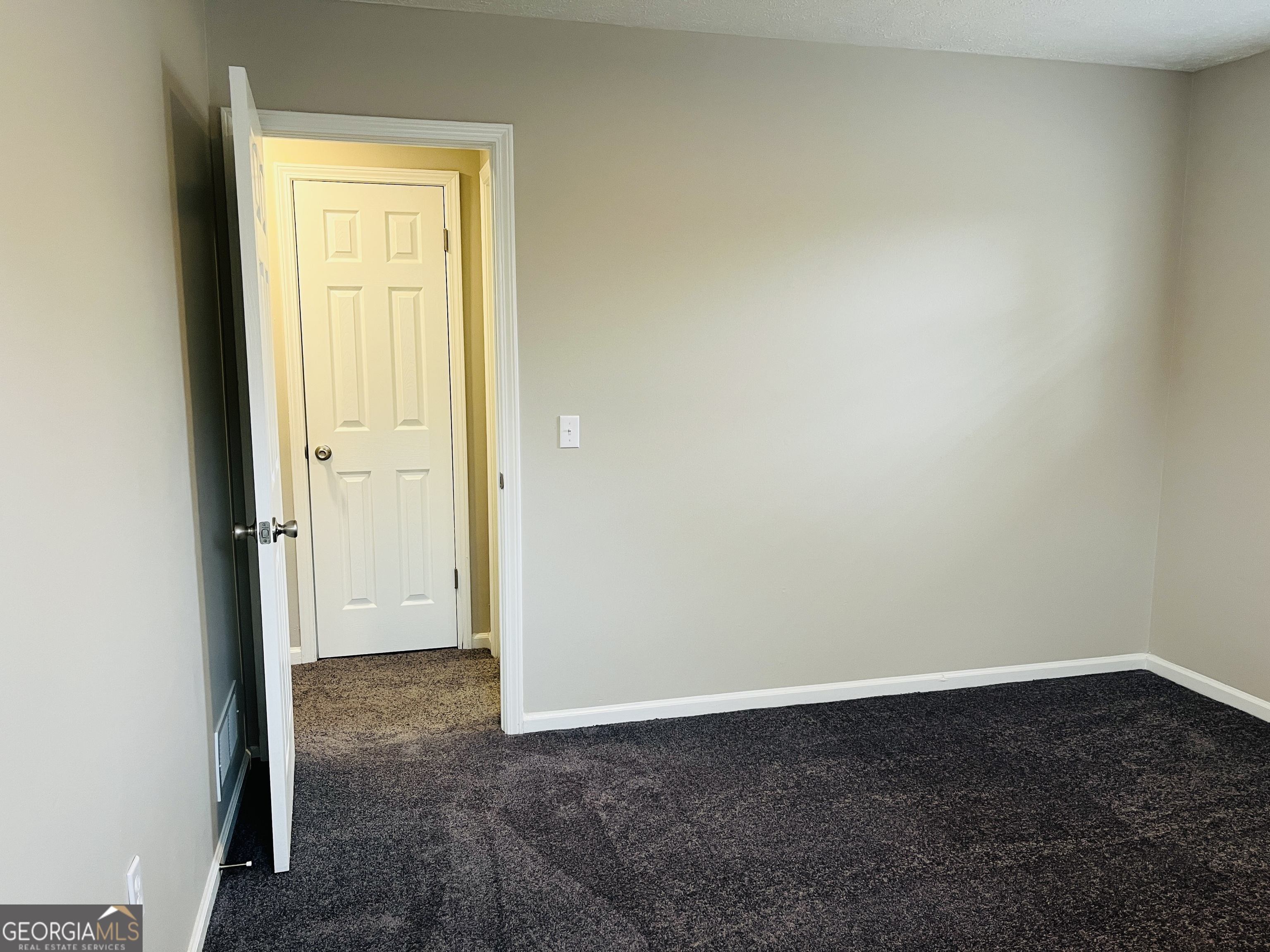 1075 Eastview Road Northeast, Unit A Conyers, GA 30012 - Photo 18 of 21 an empty room that has a grey walls