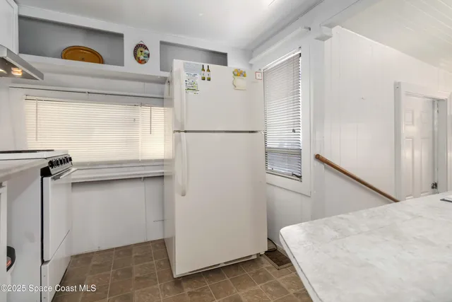 a kitchen with stainless steel appliances a white cabinets and a window