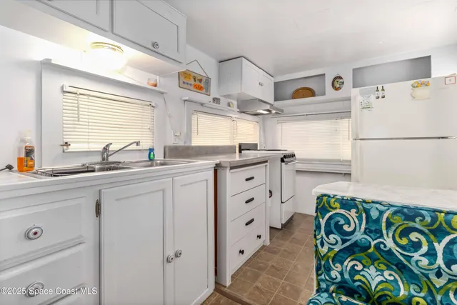 a kitchen with kitchen island a sink stove and refrigerator