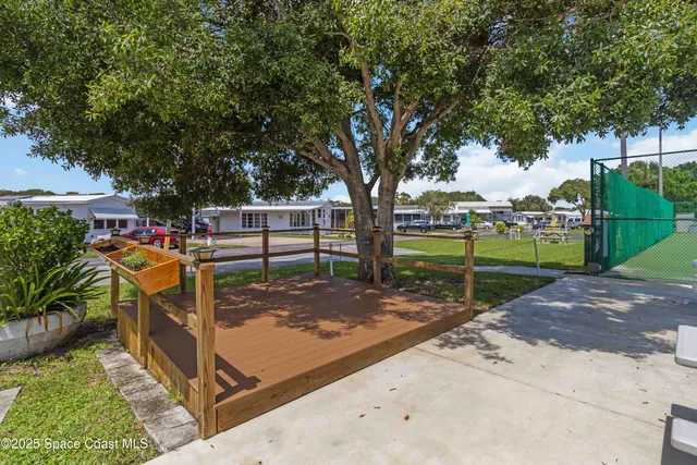 a view of a patio with table and chairs potted plants and palm tree