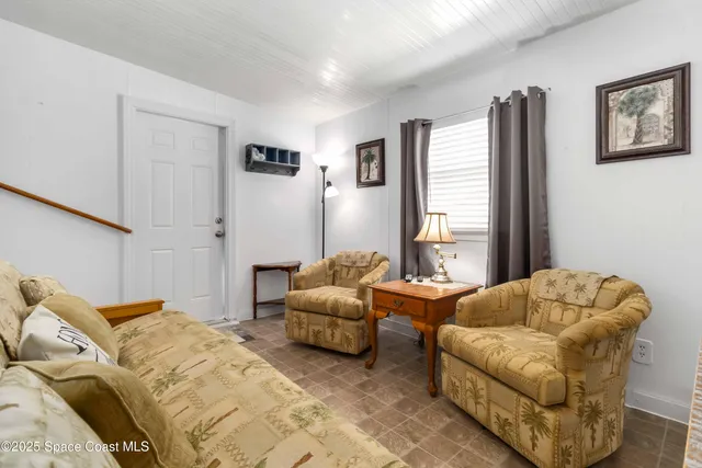 a living room with furniture a flat screen tv and a window
