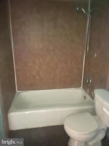 a bathroom with a toilet and bathtub