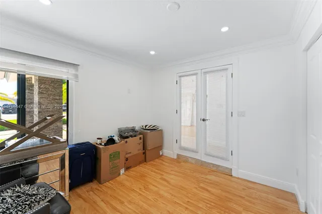 a large kitchen with kitchen island a large window a sink and stainless steel appliances