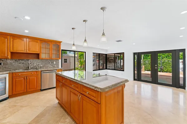a kitchen with stainless steel appliances granite countertop a sink a refrigerator and a stove
