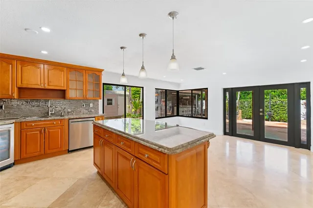 a kitchen with stainless steel appliances granite countertop a sink a refrigerator and a stove