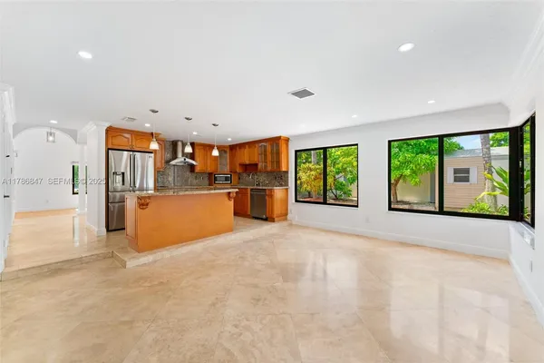 a large kitchen with stainless steel appliances granite countertop a refrigerator and a sink