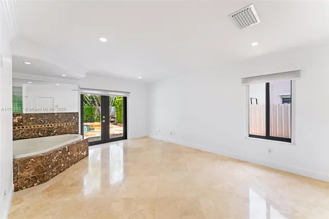a large bedroom with a bed and a view of kitchen
