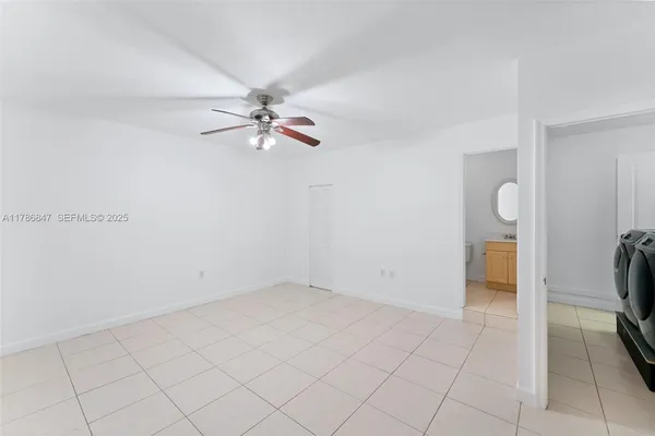 a view of an empty room and kitchen view