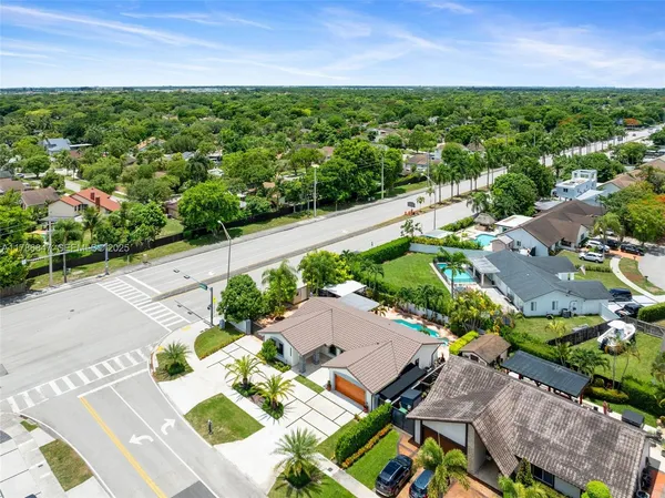 an aerial view of residential houses with outdoor space and trees