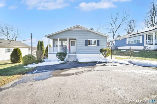 a view of a house with a yard and large tree