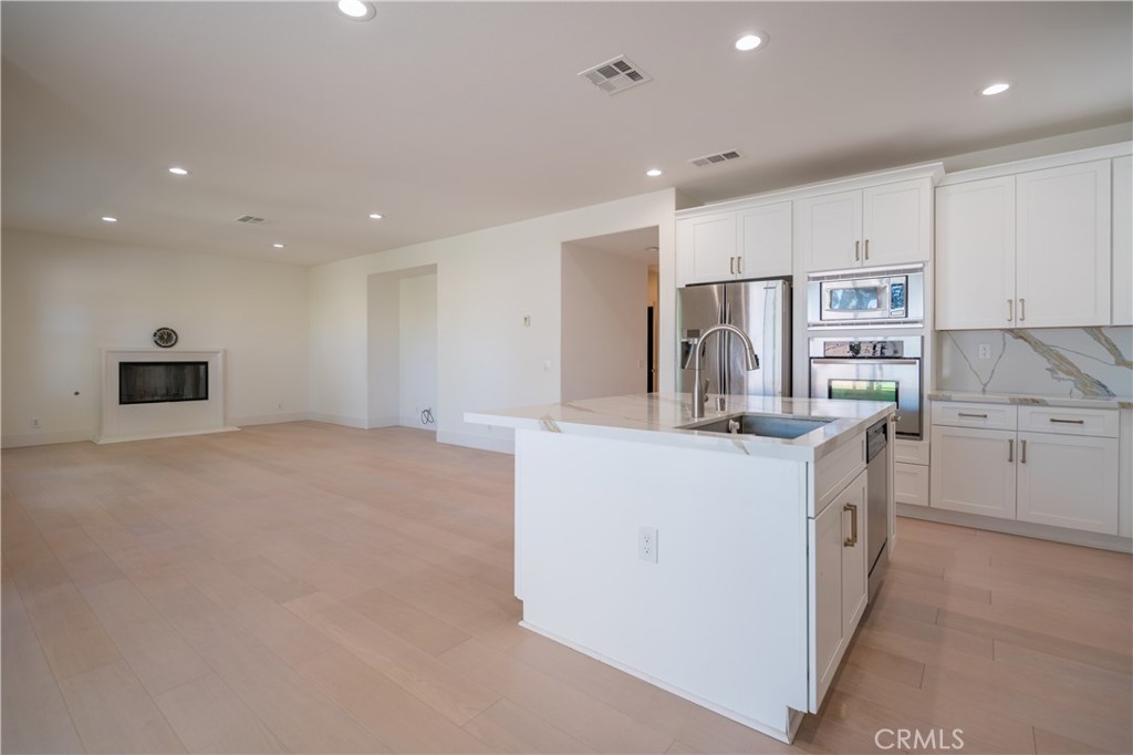 8656 Harvest Place Rancho Cucamonga, CA 91730 - Photo 11 of 39 a kitchen with kitchen island a sink stove and refrigerator