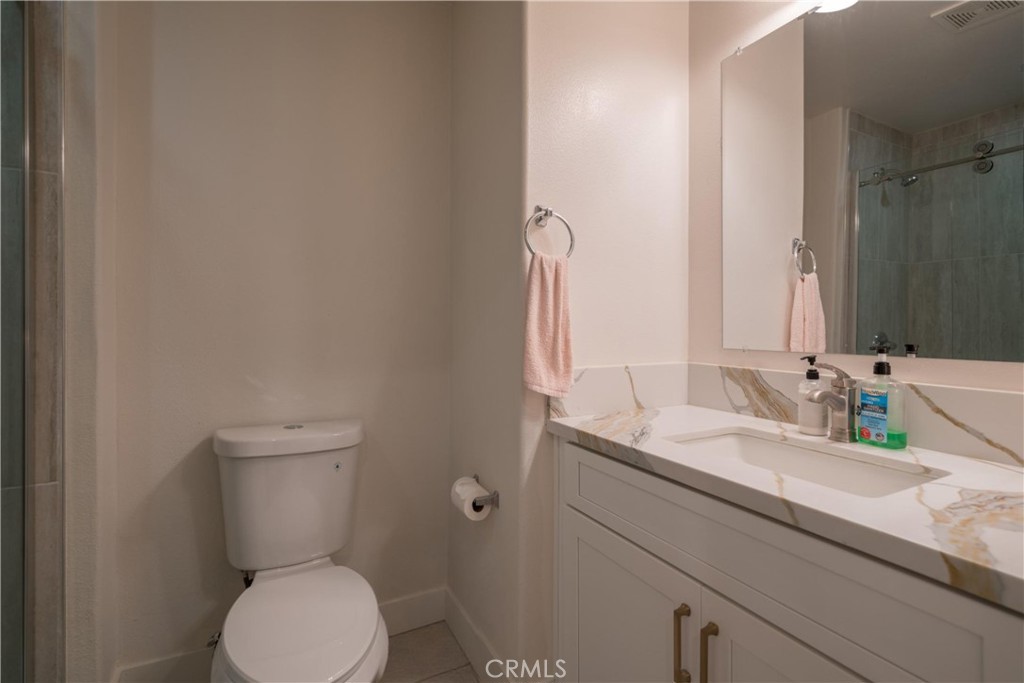 8656 Harvest Place Rancho Cucamonga, CA 91730 - Photo 14 of 39 a bathroom with a granite countertop toilet sink and mirror