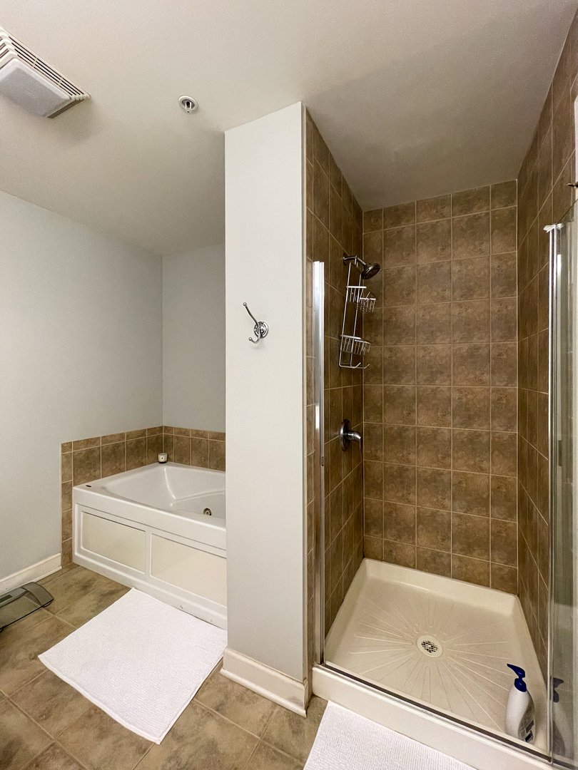451 West Huron Street, Unit 709 Chicago, IL 60654 - Photo 11 of 19 a bathroom with a bathtub and a shower