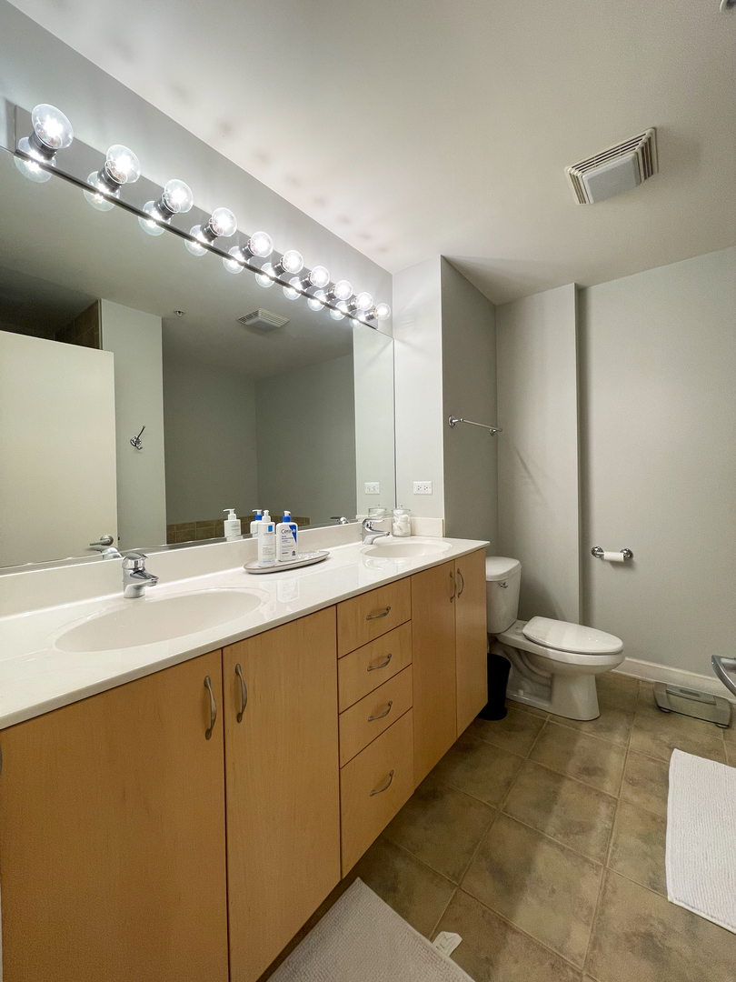 451 West Huron Street, Unit 709 Chicago, IL 60654 - Photo 10 of 19 a bathroom with a double vanity sink toilet and a mirror