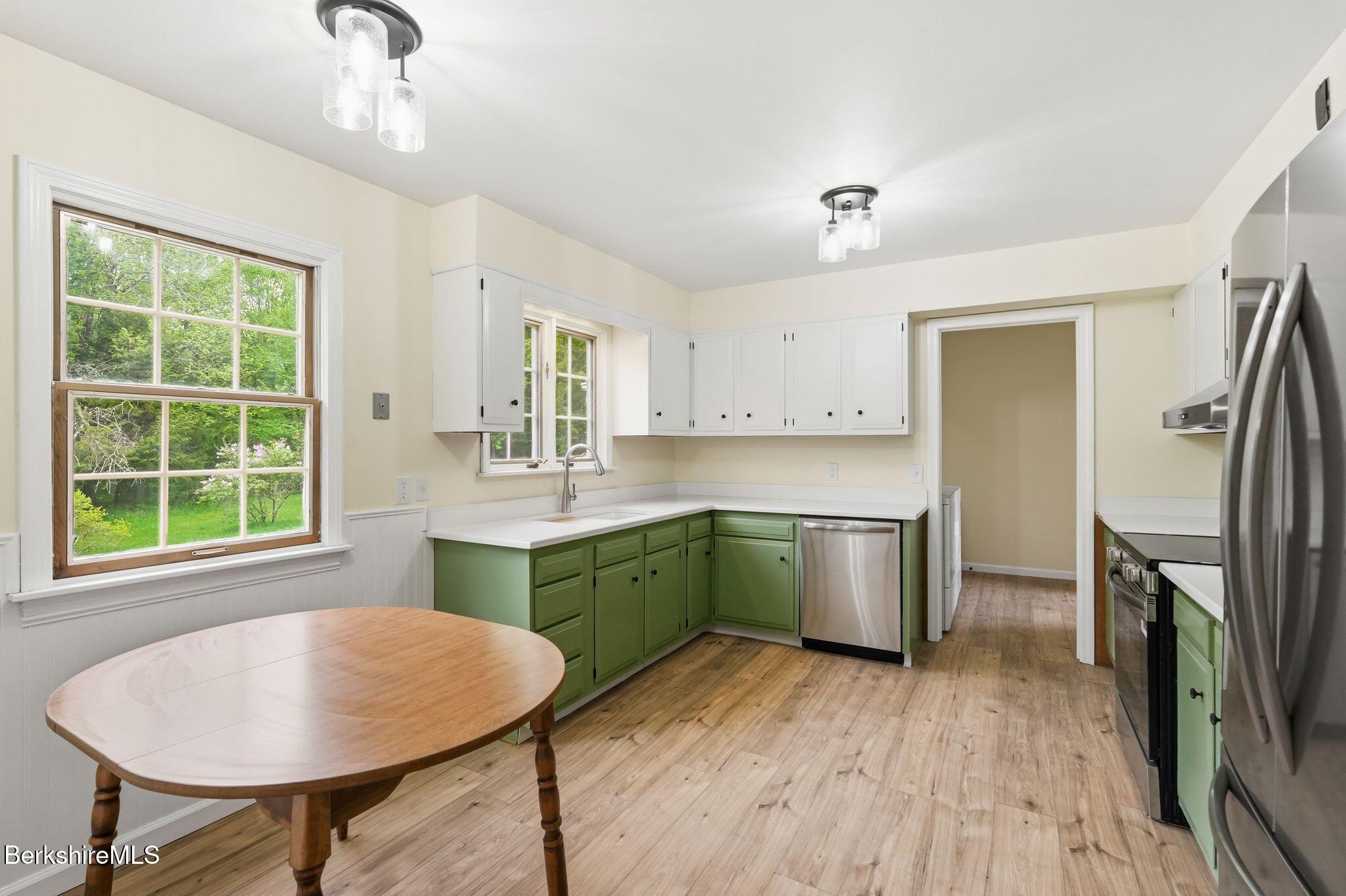 98 N Road Monroe, MA 01247 - Photo 13 of 32 a kitchen with a table chairs sink and cabinets