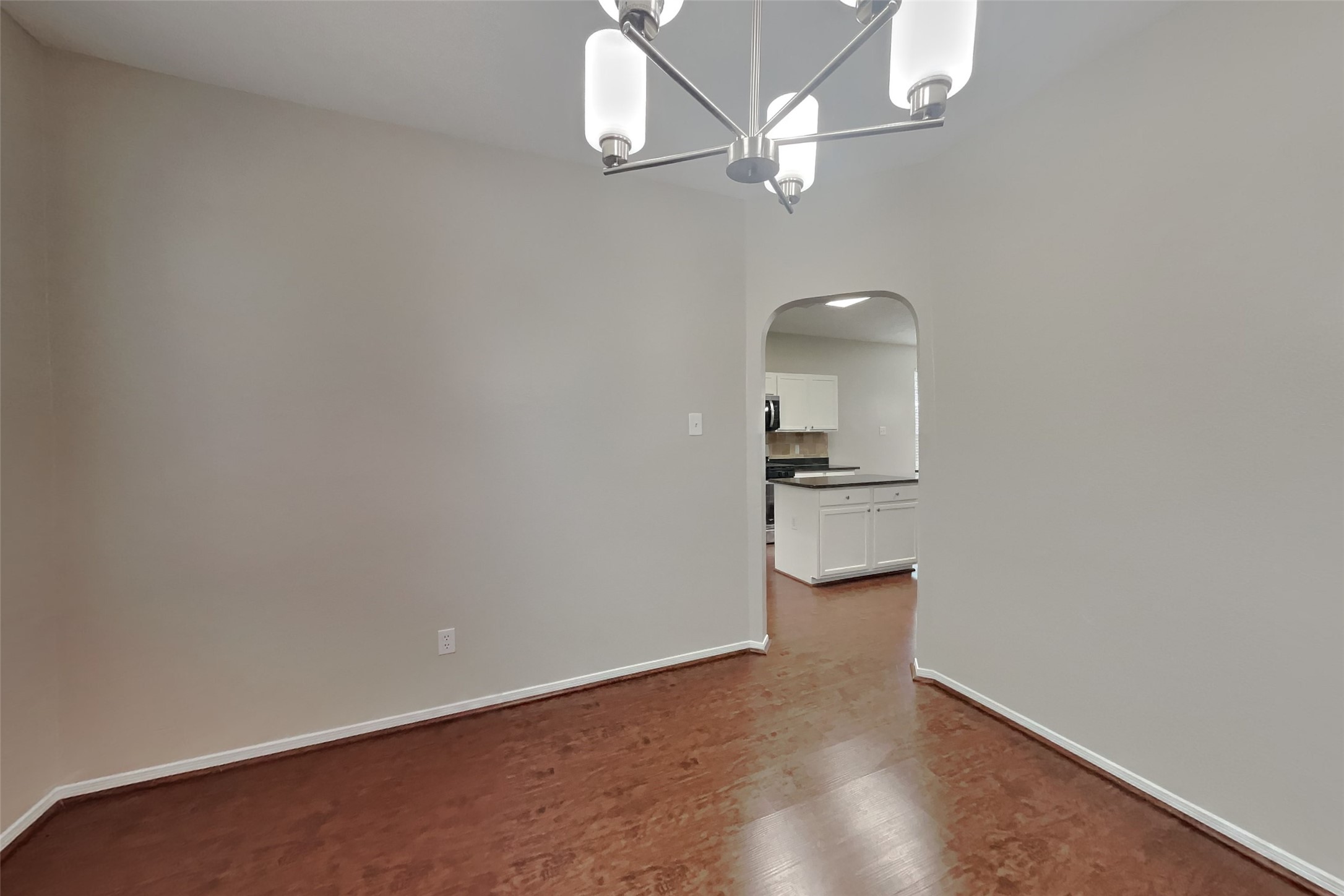 619 Bending Bough Drive Spring, TX 77388 - Photo 7 of 22 an empty room with wooden floor and kitchen view