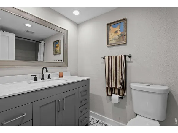 a bathroom with a toilet sink vanity and mirror