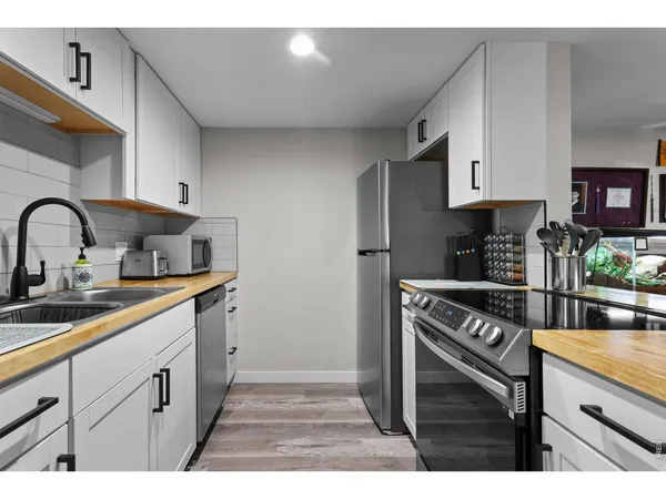 a kitchen with stainless steel appliances granite countertop a sink stove and cabinets