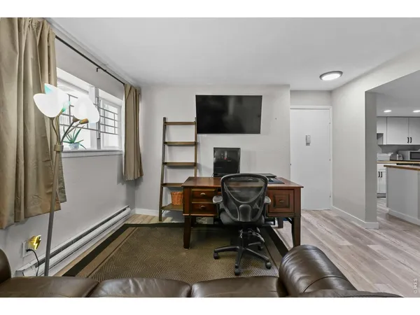 a view of a workspace with furniture and a window