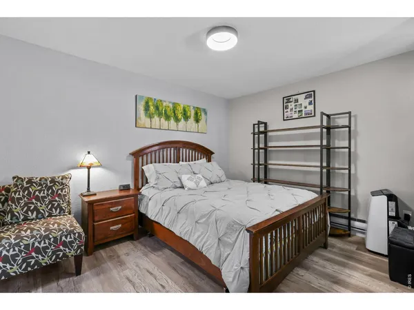 a bedroom with a bed a dresser and potted plants