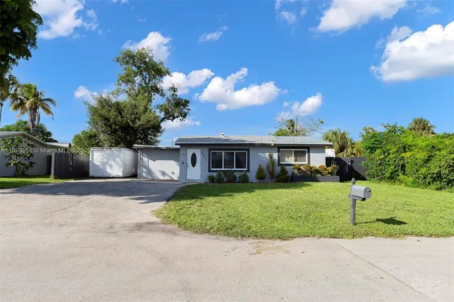 a front view of a house with a garden and trees