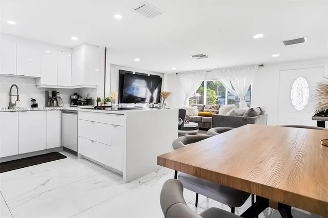 a kitchen with a stove a sink a microwave a dining table and chairs