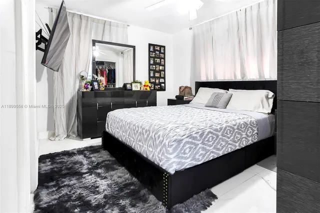 a bed sitting in a bedroom and flat screen tv