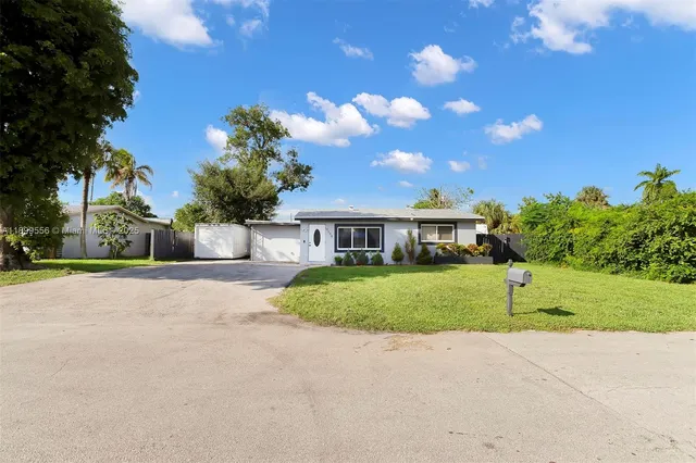 a view of a house with a big yard and a large tree