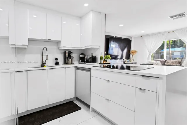 a kitchen with cabinets appliances a sink and a counter top space