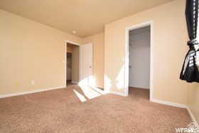 411 West 2000 South, Unit 7 Perry, UT 84302 - Photo 9 of 11 Spacious room featuring neutral carpeting and wall tones