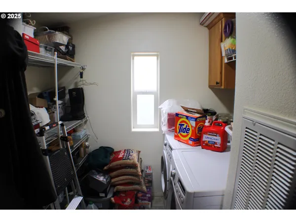 a utility room with dryer washer and shoe rack