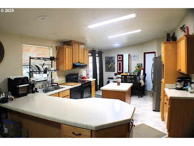 a living room with furniture a flat screen tv and a refrigerator
