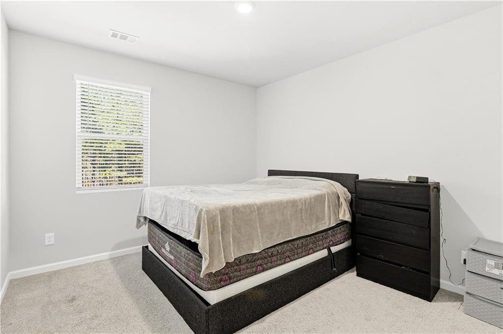 7626 Jennadee Drive Fairburn, GA 30213 - Photo 11 of 27 a bed sitting in a bedroom next to a window