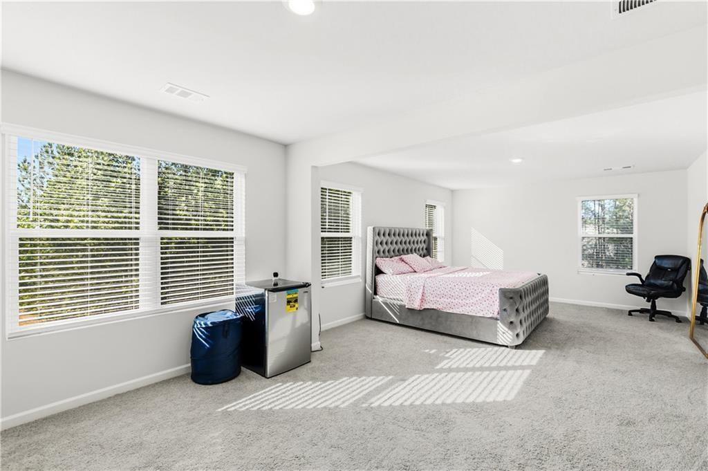 7626 Jennadee Drive Fairburn, GA 30213 - Photo 14 of 27 a spacious bedroom with a bed and a couch
