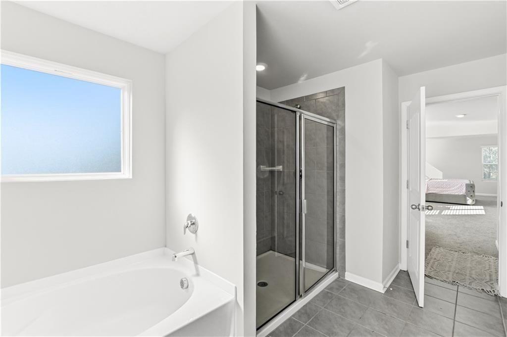 7626 Jennadee Drive Fairburn, GA 30213 - Photo 16 of 27 a bathroom with a bathtub and a shower