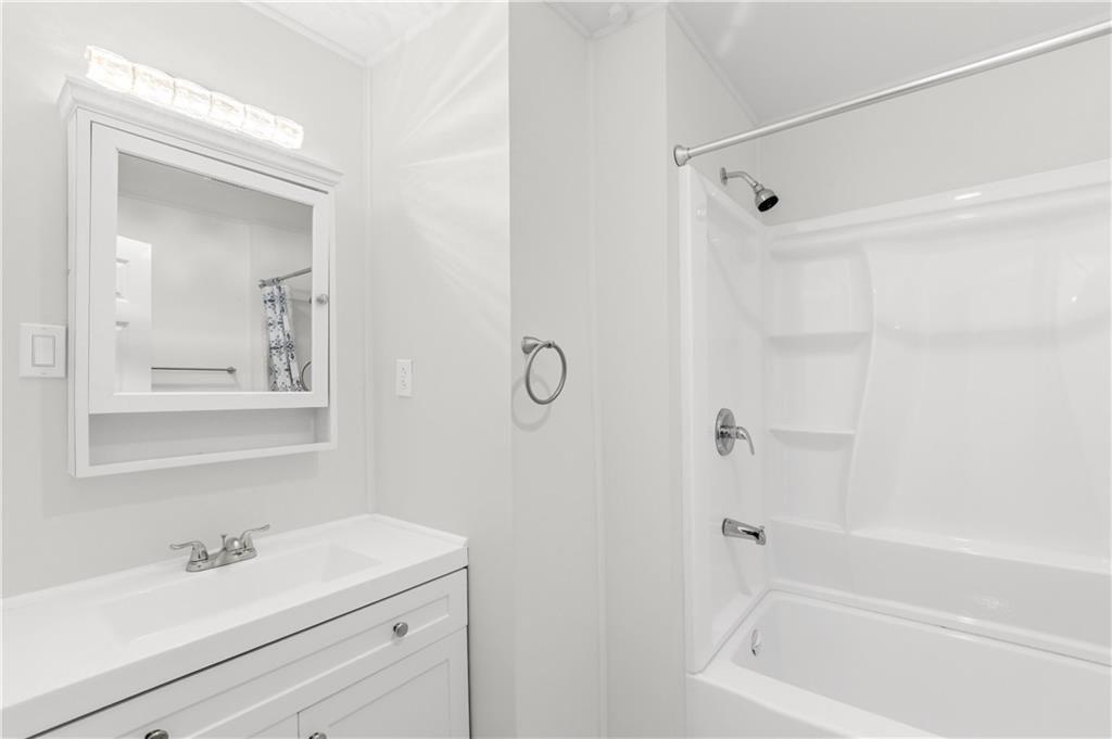 7626 Jennadee Drive Fairburn, GA 30213 - Photo 19 of 27 a bathroom with a shower sink vanity and mirror