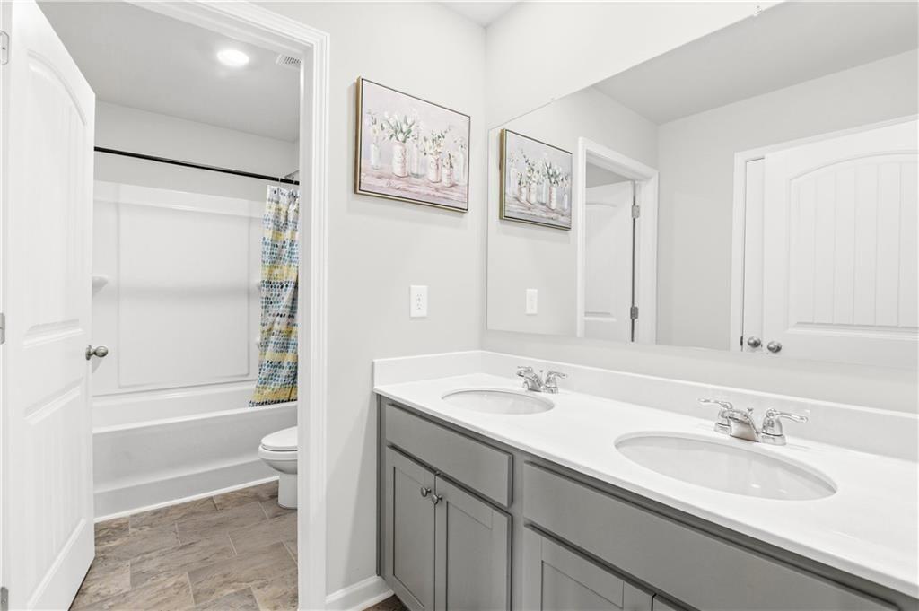 7626 Jennadee Drive Fairburn, GA 30213 - Photo 22 of 27 a bathroom with a granite countertop sink toilet and shower