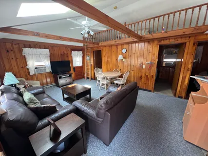 a living room with furniture a flat screen tv and a large window