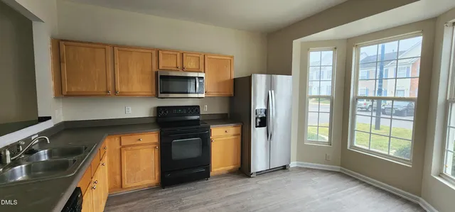 a kitchen with stainless steel appliances granite countertop a refrigerator stove and sink
