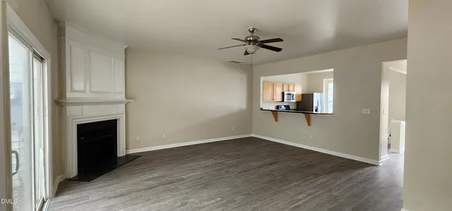 a view of a livingroom with wooden floor and a ceiling fan