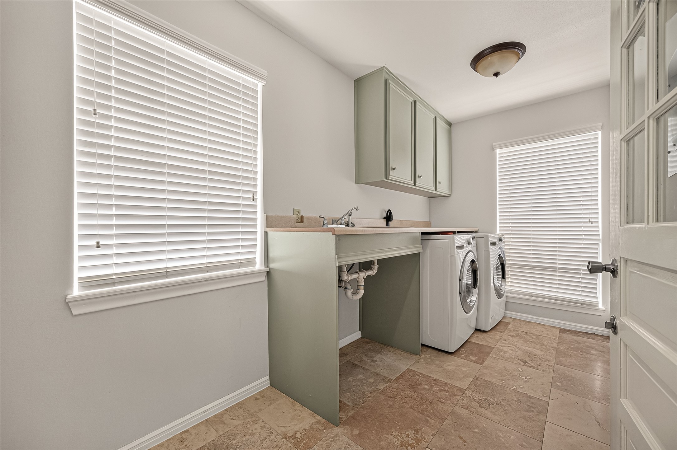 8007 Vickridge Lane Spring, TX 77379 - Photo 14 of 44 Conveniently located just off the kitchen, the spacious laundry room offers abundant natural light, built-in storage, and a convenient door leading to the covered walkway connecting the garage and backyard