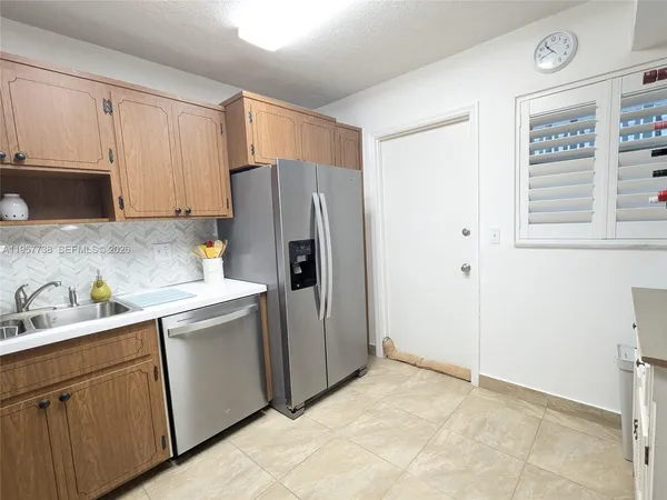 a kitchen with a refrigerator sink and cabinets