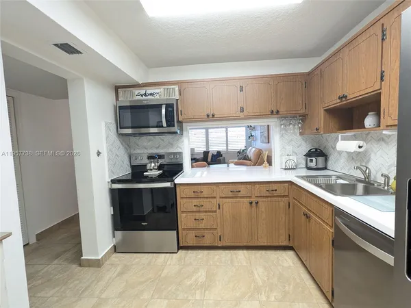 a kitchen with stainless steel appliances granite countertop a sink and stove top oven
