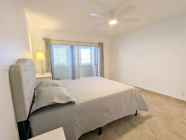 a bedroom with a bed and chair with window