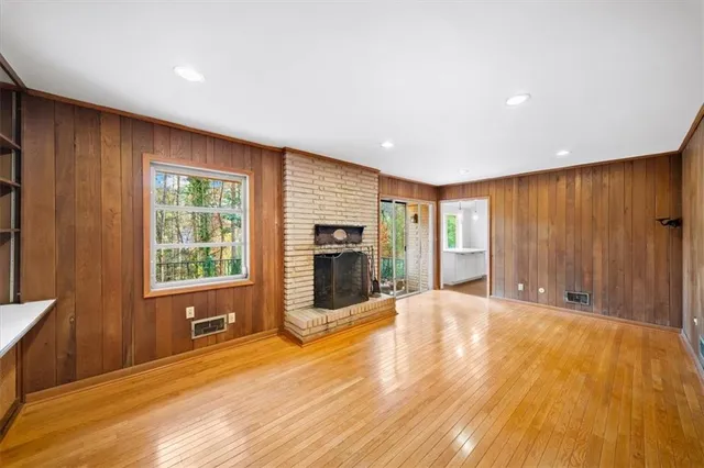 a view of an empty room with a window and fire place