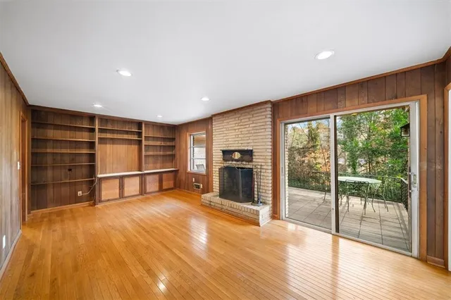 a view of empty room with wooden floor and fireplace