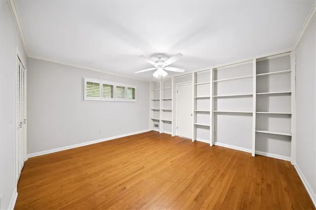 a view of a bedroom with a cabinet and a ceiling fan