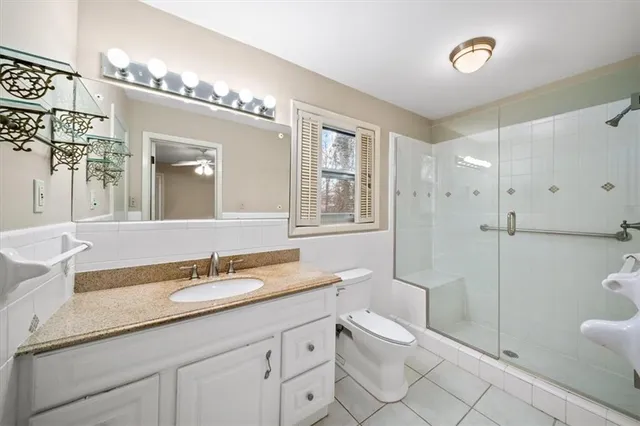 a bathroom with a granite countertop sink mirror and toilet