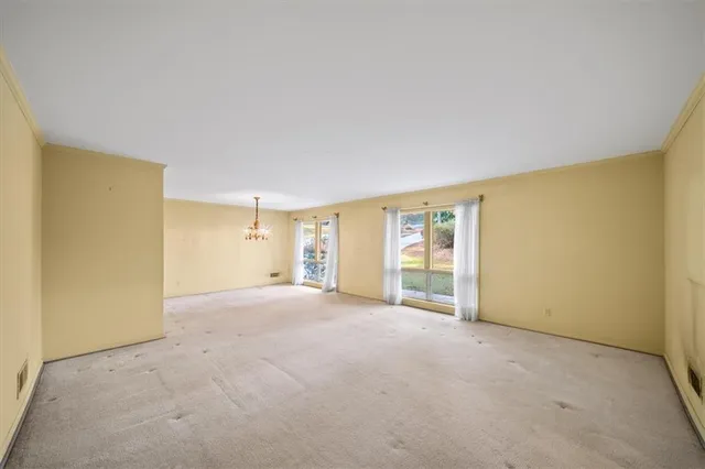 an empty room with a fireplace and large windows